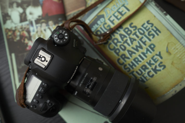 A camera rests on a table next to a menu listing seafood items like crabs, crawfish, and shrimp.