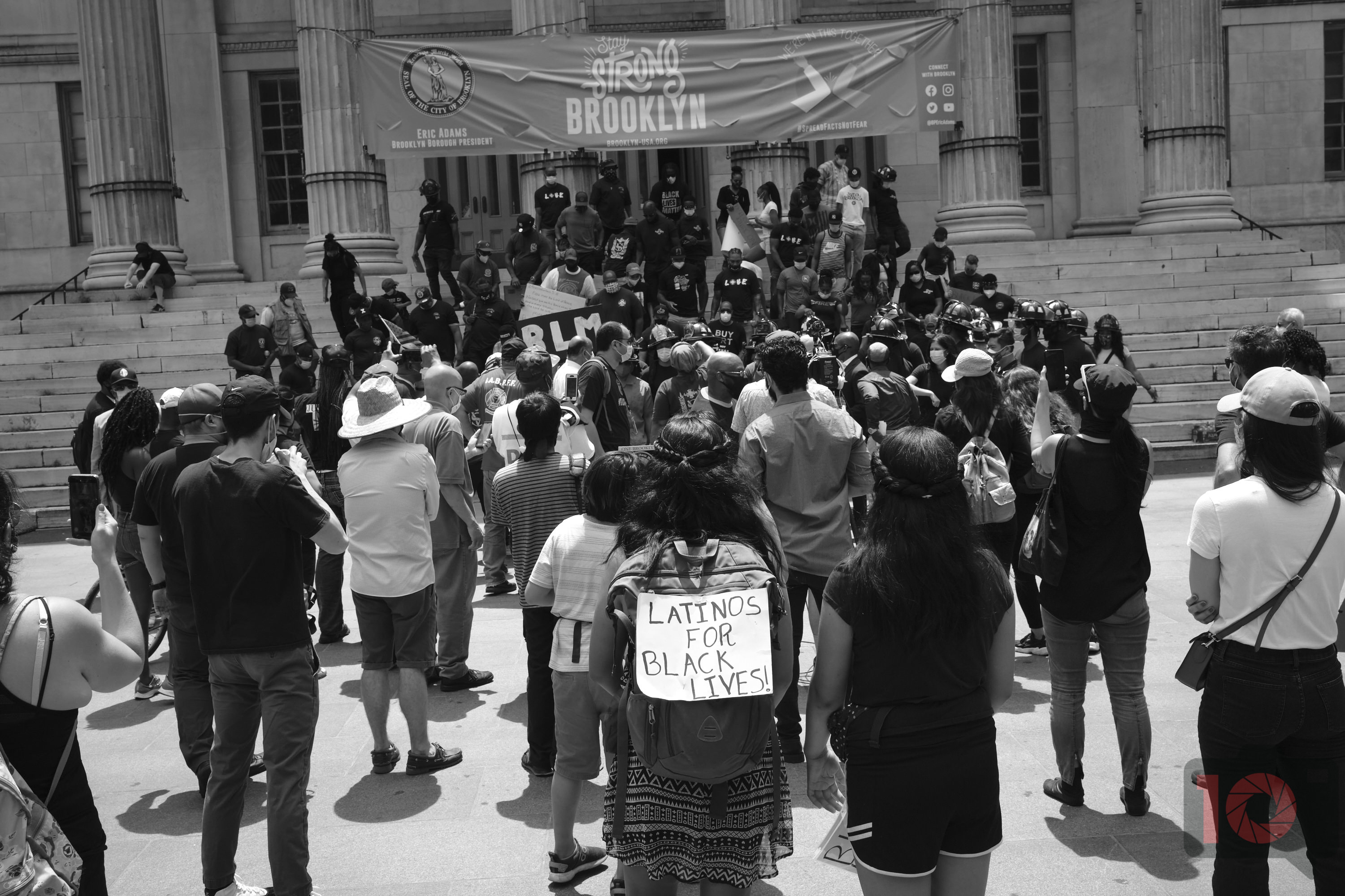 A crowd gathers at a Brooklyn protest; one person’s sign reads “Latinos for Black Lives.”.