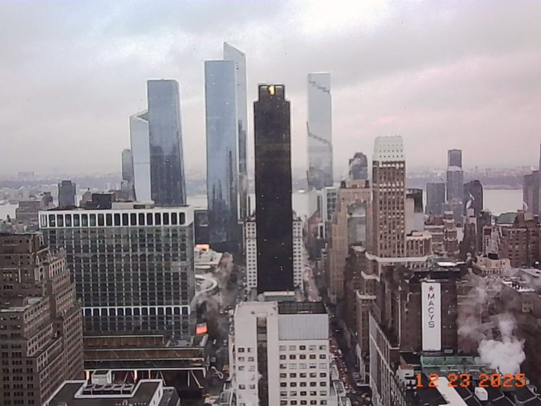 A cloudy cityscape view of tall skyscrapers and busy streets in Manhattan, New York, dated 12-23-2023.