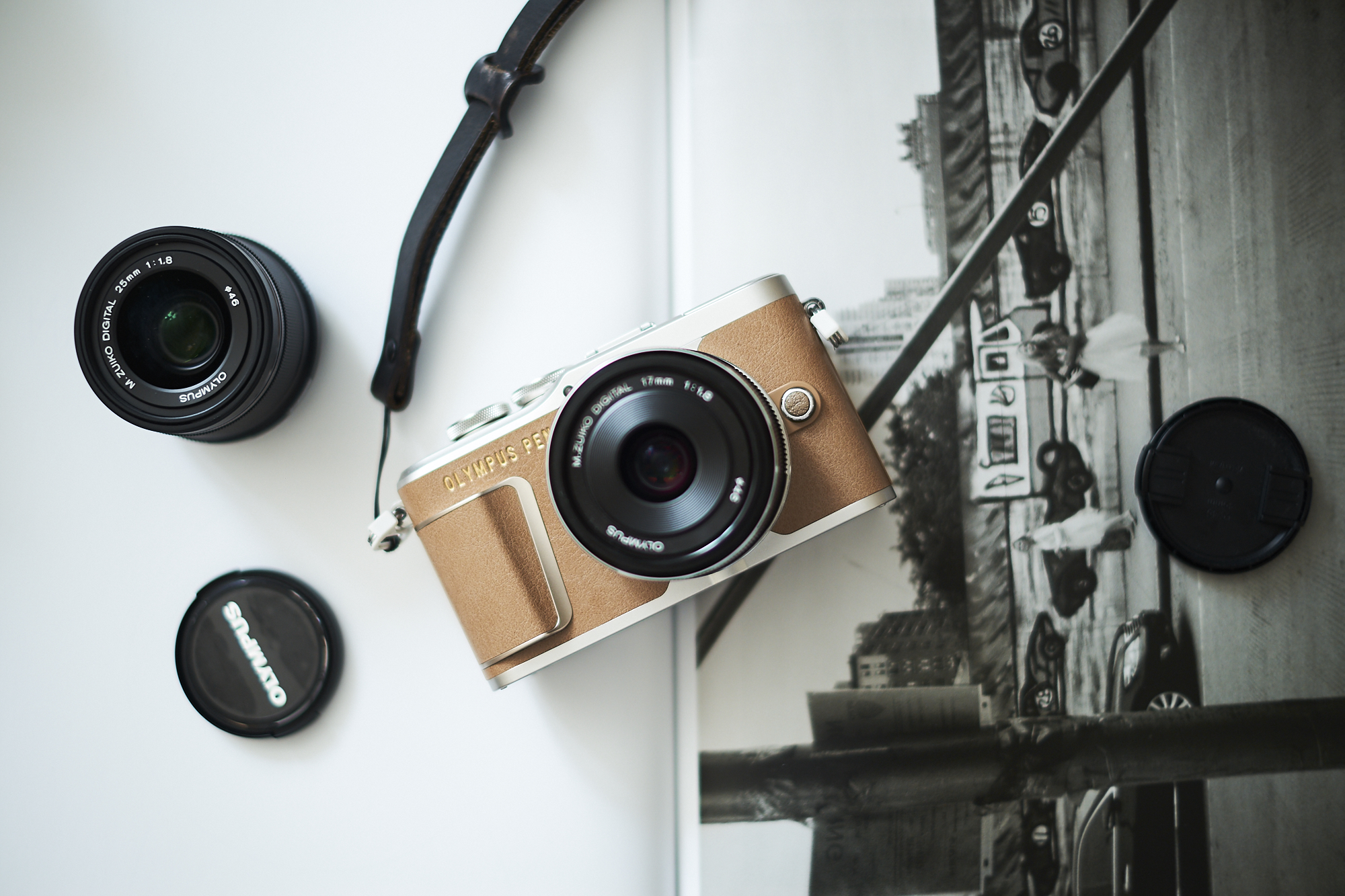 A vintage camera with lenses and a lens cap lies on an open black-and-white photo book.