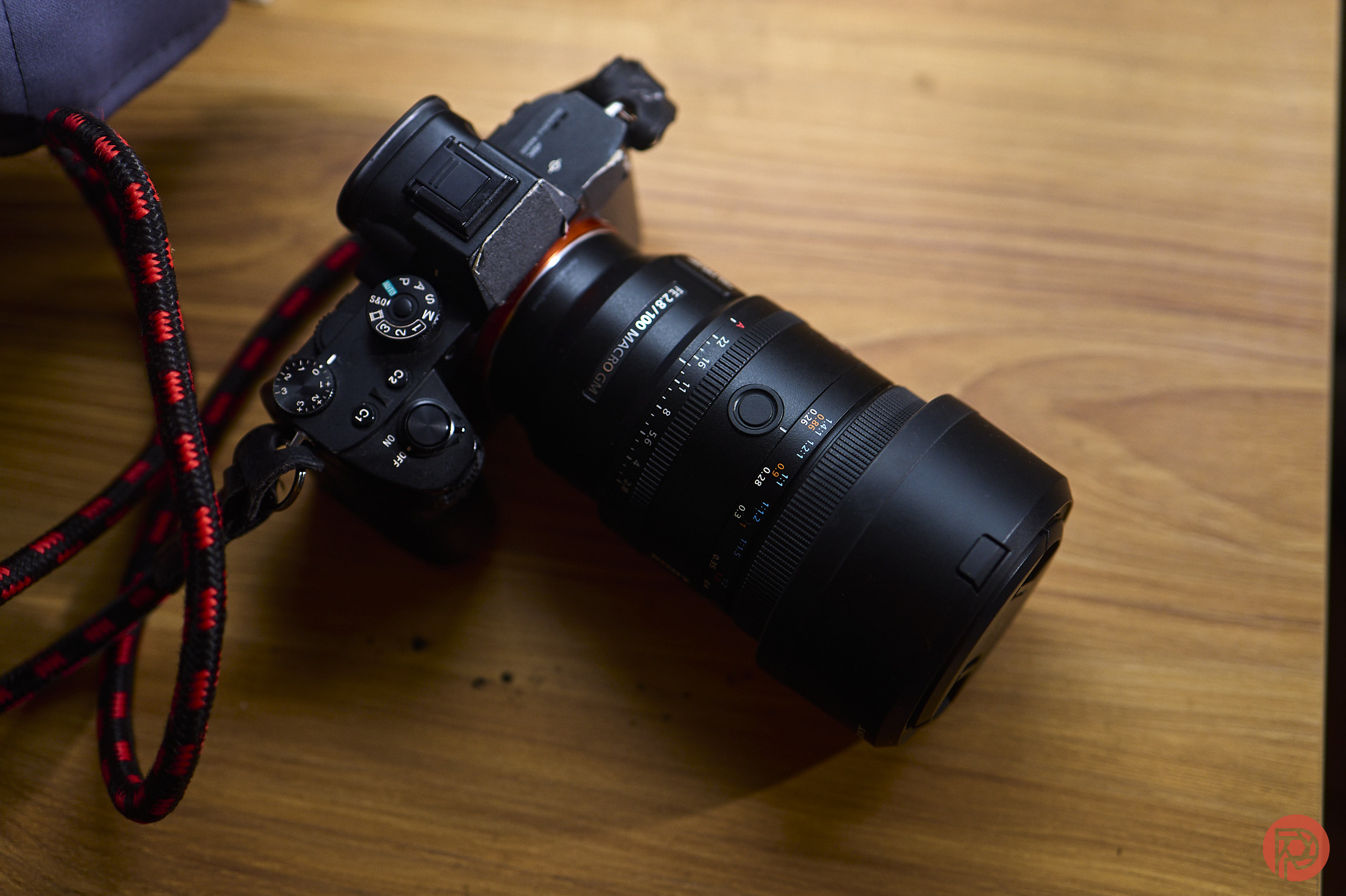 A black Sony camera with a large lens rests on a wooden surface.