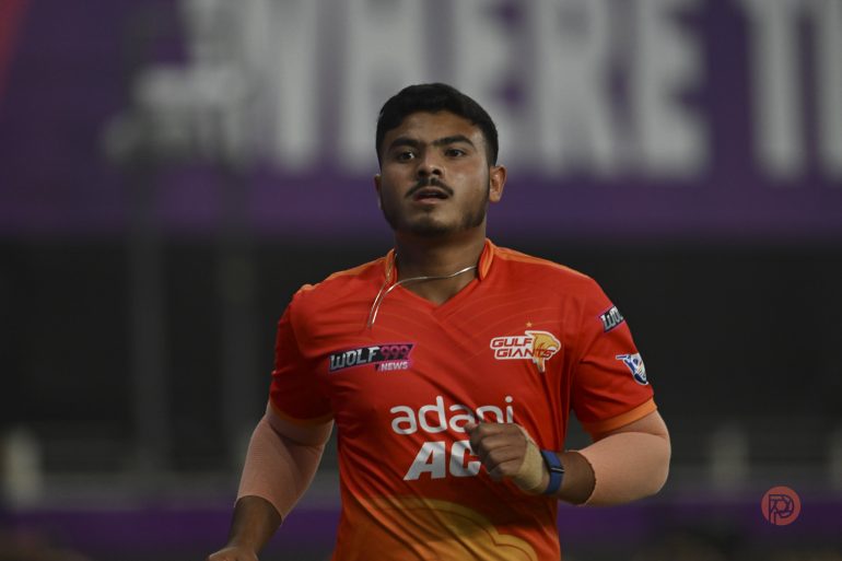 A cricket player in an orange Gulf Giants jersey runs on the field during a match.