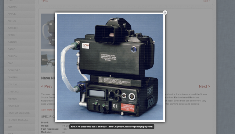 A close-up of a vintage NASA electronic still camera with various buttons, dials, and a large viewfinder.